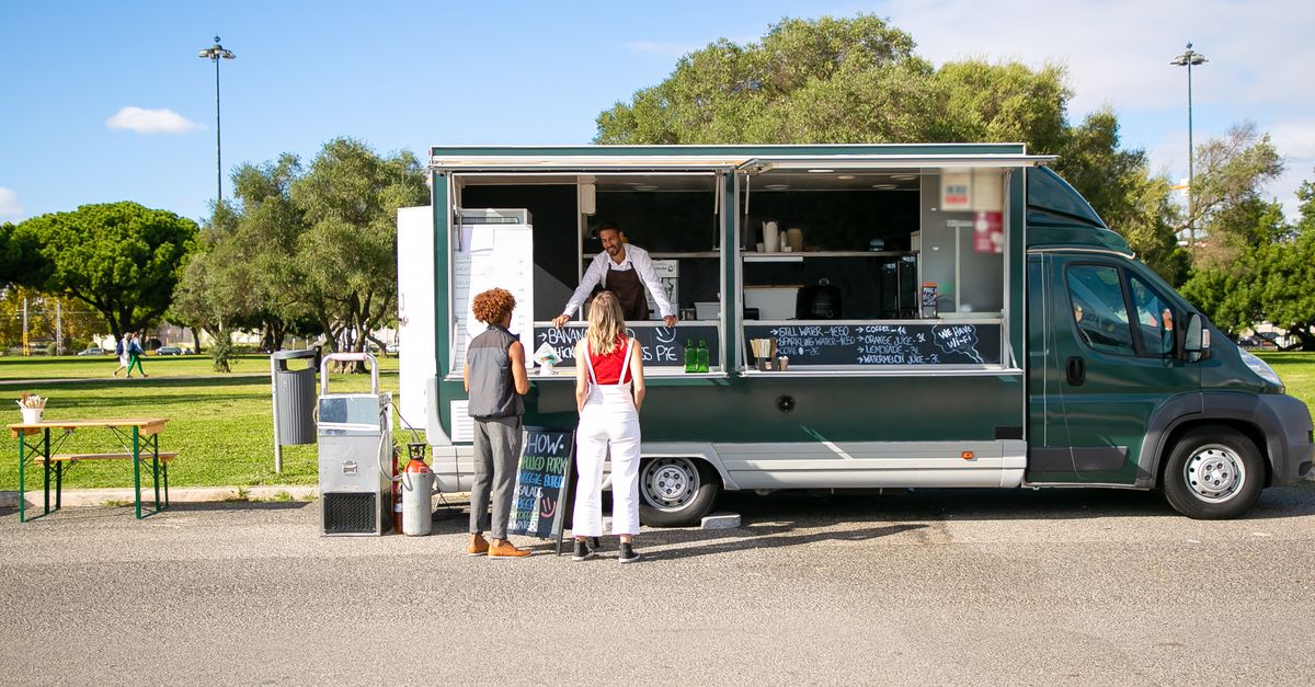 Customers ordering from a food truck at an outdoor park, similar to the food truck scene around Pasco County, Florida