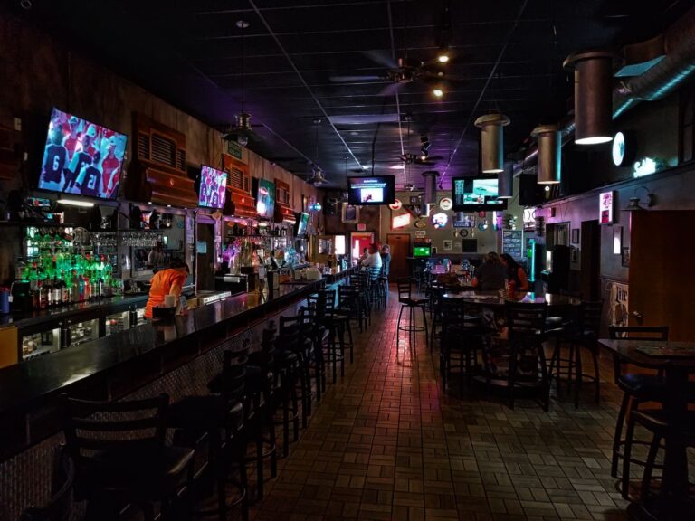 Interior of a sports bar with multiple TV screens and bar seating