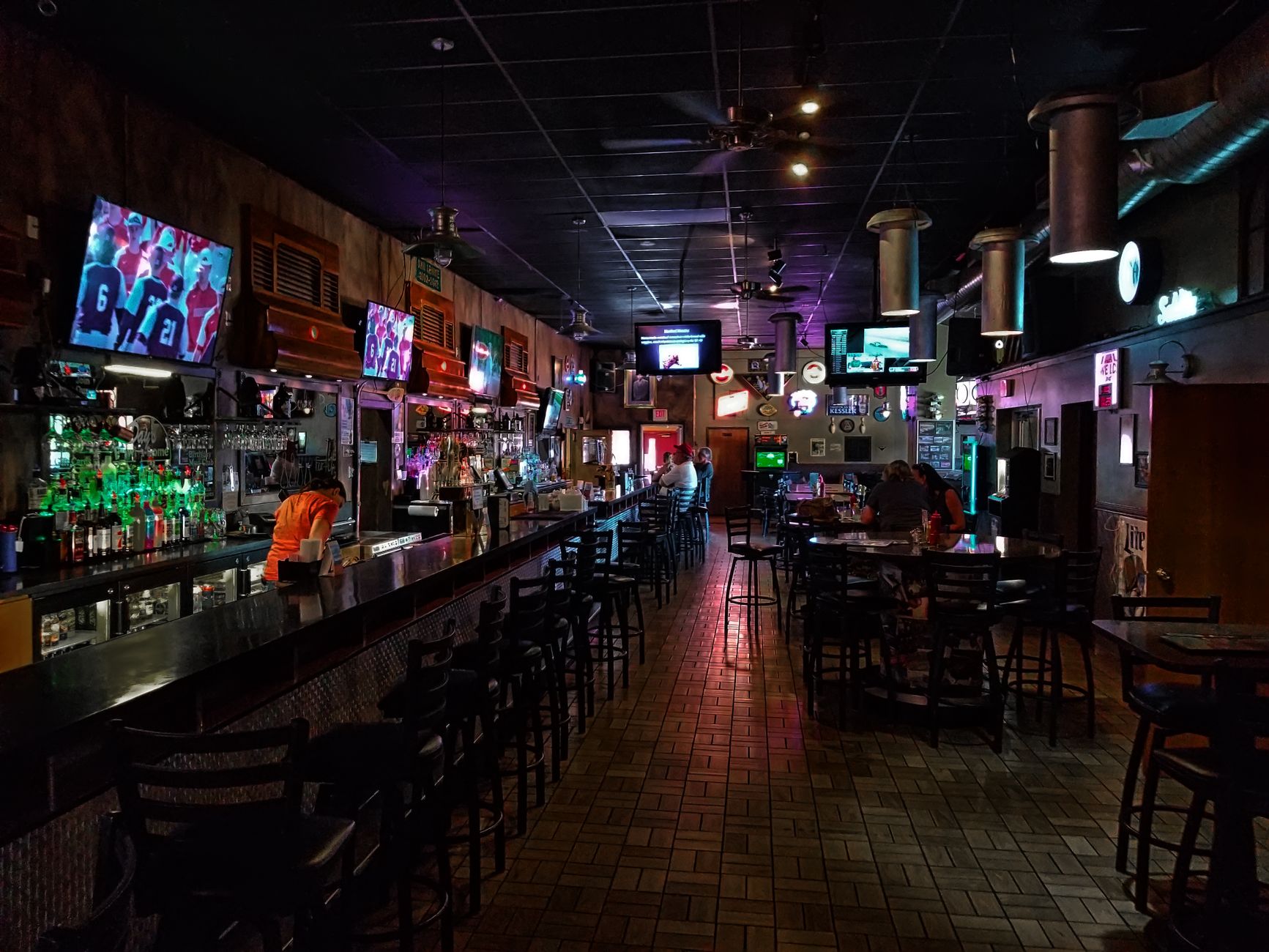 Interior of a sports bar with multiple TV screens and bar seating
